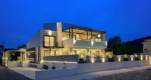 a large white house at night with lights at Alea Suites -Adults Only and Kids 14 Plus in Asprovalta