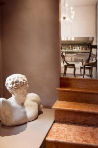 una estatua de un busto sentada en una mesa al lado de las escaleras en Castellata La Suite, en Bolonia