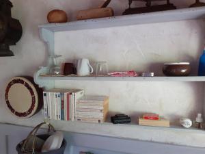 a shelf with books and other items on it at La cabane de l'oiseau in Couze-et-Saint-Front