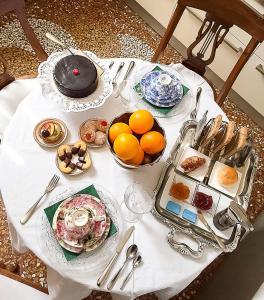 una mesa blanca con platos de comida. en Castellata La Suite, en Bolonia
