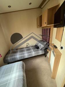 a room with a bed and a desk and a tv at Tranquility - Static Caravan Lune Park on Parkdean Ocean Edge Resort in Heysham