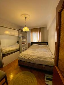 een kleine slaapkamer met 2 bedden en een kroonluchter bij In the city center (800m from Cevahir shopping) in Istanbul