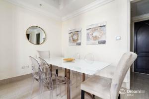 a dining room with a white table and chairs at Dream Inn Apartment- Tajer Souk Al Bahar in Dubai