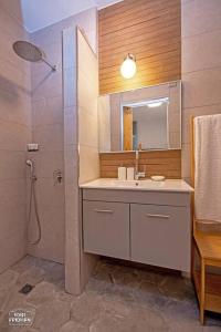 a bathroom with a shower and a sink and a mirror at הרימון- צימר בוטיק לזוג במעלה גמלא in Ma'ale Gamla