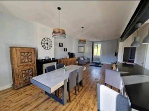 a dining room and living room with a table and chairs at Spacieux Cosy in Blaye-les-Mines +2 photos