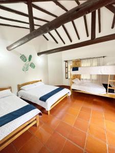 two beds in a room with wooden ceilings at Lo Nuestro - Hospedaje in Villa de Leyva