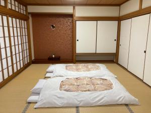 a room with four beds in a room at Yoshiharu in Toyooka