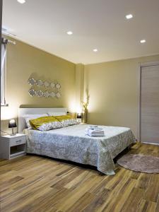 a bedroom with a large bed and a wooden floor at Athena Agrigento Apartments in Agrigento