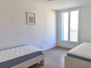 1 Schlafzimmer mit 2 Betten und einem Fenster in der Unterkunft Spacious 3-bedroom apartment with terrace and AC in the city centre in Avignon