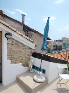 un paraguas azul en el techo de un edificio en Attico romantico con terrazza Sanremo - Palm Street, 104, en San Remo