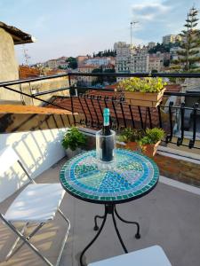 Una botella de vino sentada en una mesa en un balcón en Attico romantico con terrazza Sanremo - Palm Street, 104, en San Remo