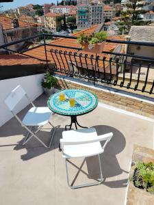 una mesa y sillas en un balcón con vistas en Attico romantico con terrazza Sanremo - Palm Street, 104, en San Remo