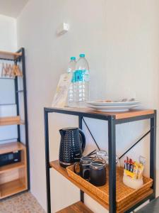 a shelf with plates and water bottles on it at Thong Nai Pan Beach Residence in Thong Nai Pan Yai