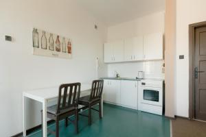 華沙的住宿－Hidden Peak Guestrooms，厨房配有白色的桌子和两把椅子