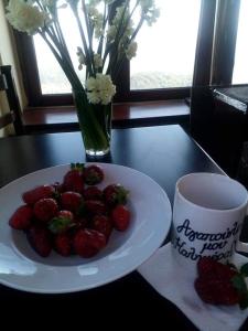 un plato de fresas en una mesa junto a una taza en Hotel Isaraiko Spiti Agia Theodora, en Isaris