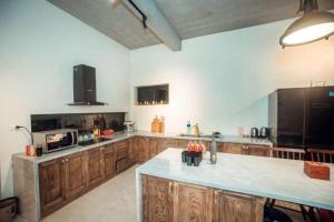 a large kitchen with wooden cabinets and a large island at 1992 Tam Đảo - Venuestay in Tam Ðảo
