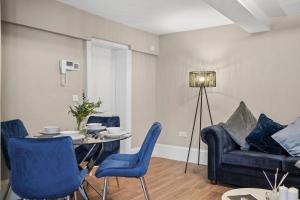 een woonkamer met een tafel en stoelen en een bank bij Chic & Contemporary Apartment with Patio - Parking in Wakefield