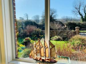 a stained glass window with a view of a garden at Sandy Shores, 3 min walk to beach & Swanage centre in Ulwell