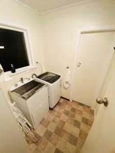 baño pequeño con lavabo y ventana en Rosedale Retreat en Invercargill