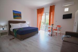 a bedroom with a bed and a table and a couch at Camera & Caffè - Accoglienza Salentina in Villaggio Resta