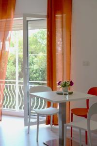a white table and chairs in a room with a window at Camera & Caffè - Accoglienza Salentina in Villaggio Resta