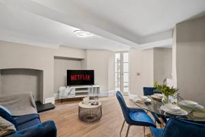 een woonkamer met een tafel en stoelen en een televisie bij Chic & Contemporary Apartment with Patio - Parking in Wakefield