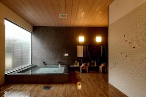 a large bathroom with a tub in a room at ミヤマテラス in Nantan city