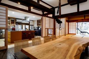 a kitchen and dining room with a wooden table and chairs at ミヤマテラス in Nantan city