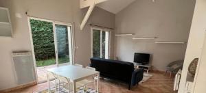 uma sala de estar com um sofá e uma mesa em Appartement jardin 4 couchages proche aéroport Groupama stadium eurexpo em Saint-Bonnet-de-Mure
