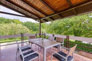 a patio with a table and chairs on a deck at Lovely House Near Zagreb With Terrace - Happy Rentals in Graberje Ivanićko