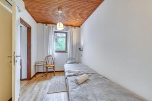 a bedroom with a bed and a table and a window at Lovely House Near Zagreb With Terrace - Happy Rentals in Graberje Ivanićko