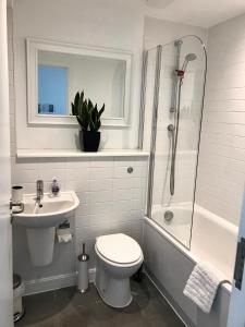 a bathroom with a toilet and a sink and a shower at Bedford Central Apartment with Free Secure Parking in Bedford
