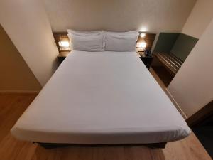 A bed or beds in a room at HelloSky Air Rooms Madrid