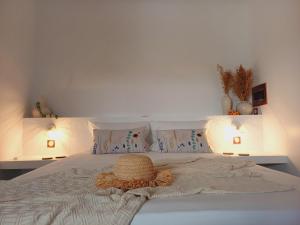 a bedroom with a bed with a hat on it at Philoxenia, maison et table d'hôtes in La Saline les Bains