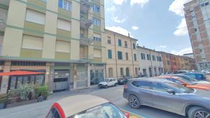 una fila de autos estacionados frente a un edificio en RomagnaBNB Cignani en Forlì