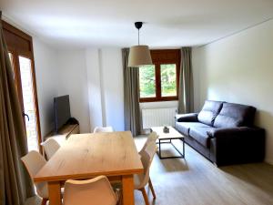 sala de estar con mesa y sofá en Apartaments Turistics El Buner, en Ordino