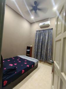 um quarto com uma cama e uma ventoinha de tecto em D Embun Homestay em Pasir Mas