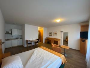 a bedroom with a bed and a table and a kitchen at Ariva Boardinghouse Platanenhof in Mannheim