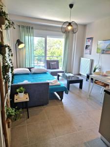a bedroom with a blue bed and a living room at Palaia premium flat in Volos
