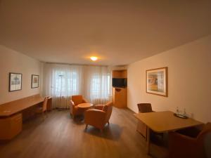een woonkamer met een tafel en stoelen en een bureau bij Ariva Boardinghouse Platanenhof in Mannheim