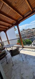 a balcony with a table and chairs on a building at Fori's Nest Home SKG in Thessaloniki