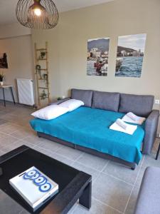 a living room with a blue couch and a table at Palaia premium flat in Volos