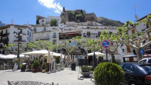 eine Gruppe von Gebäuden mit Tischen und Sonnenschirmen in der Unterkunft Casa Chica in Cazorla