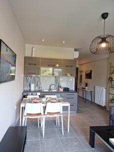 cocina con mesa y sillas blancas en una habitación en Palaia premium flat en Volos
