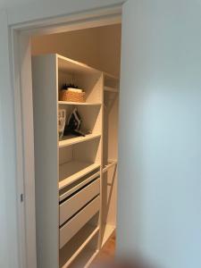 a closet with white shelves and a white door at Grande monolocale con parcheggio interrato incluso in Genoa