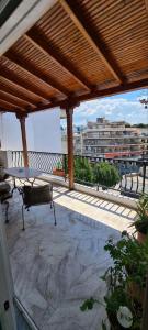 a patio with a table and bench on a roof at Fori's Nest Home SKG in Thessaloniki