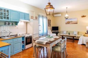 a kitchen and living room with blue cabinets and a table at Yellow Bike House in Lefkimmi