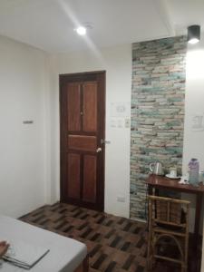 a room with a wooden door and a stone wall at Raje Residence in El Nido