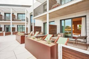 an outdoor patio with chairs and tables on a building at Silken Platja d'Aro in Platja  d'Aro