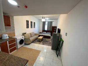 a kitchen and living room with a couch and a microwave at Apartment in Ajman,Studio flat in Ajman 